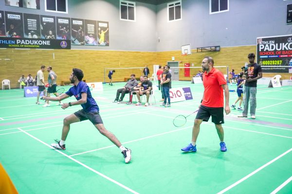 An ANRIA Qatar player mid-rally during a badminton tournament