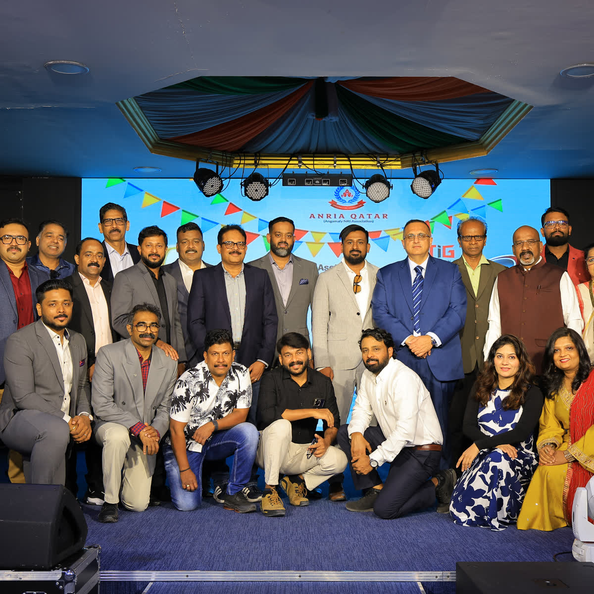 Committee members and guests photographed together on stage at an Onam celebration