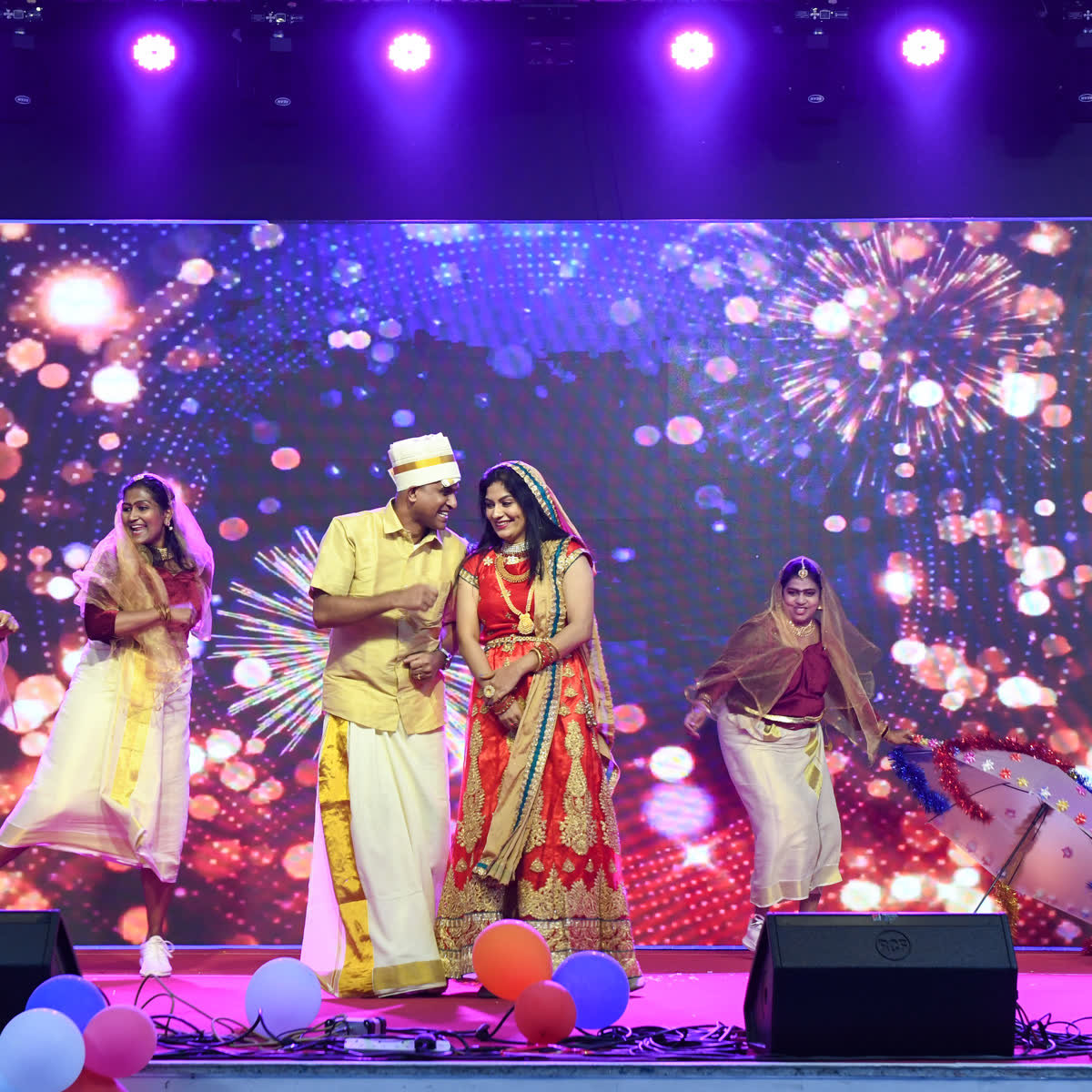 A couple performing a dance item against a sparkling stage backdrop