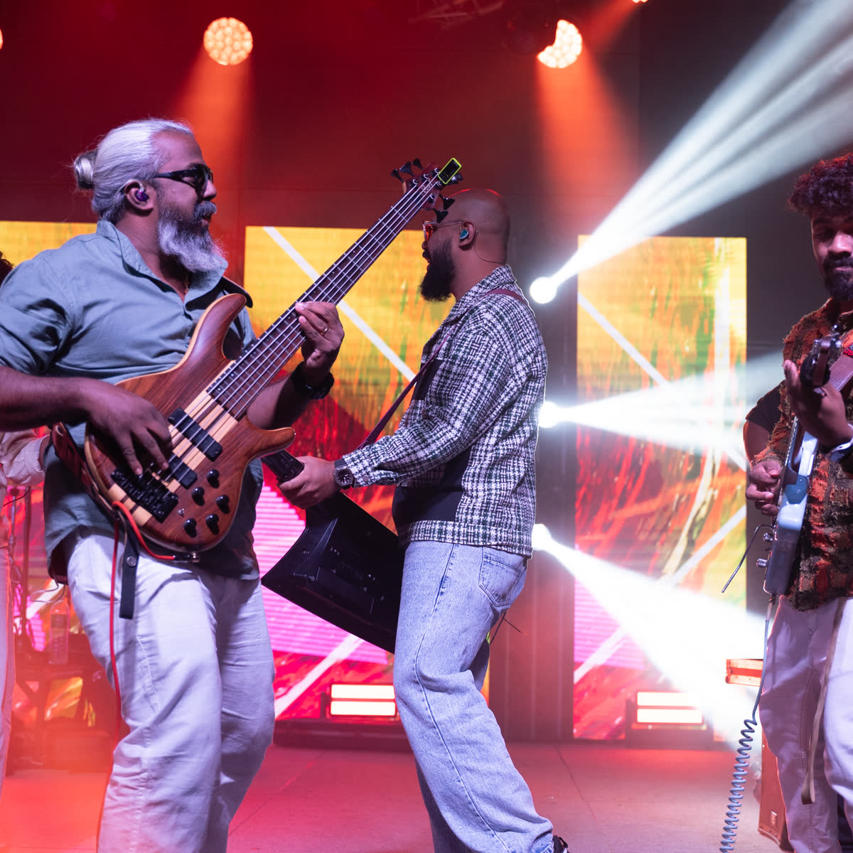 A bass guitarist performing under stage lights at a live music evening