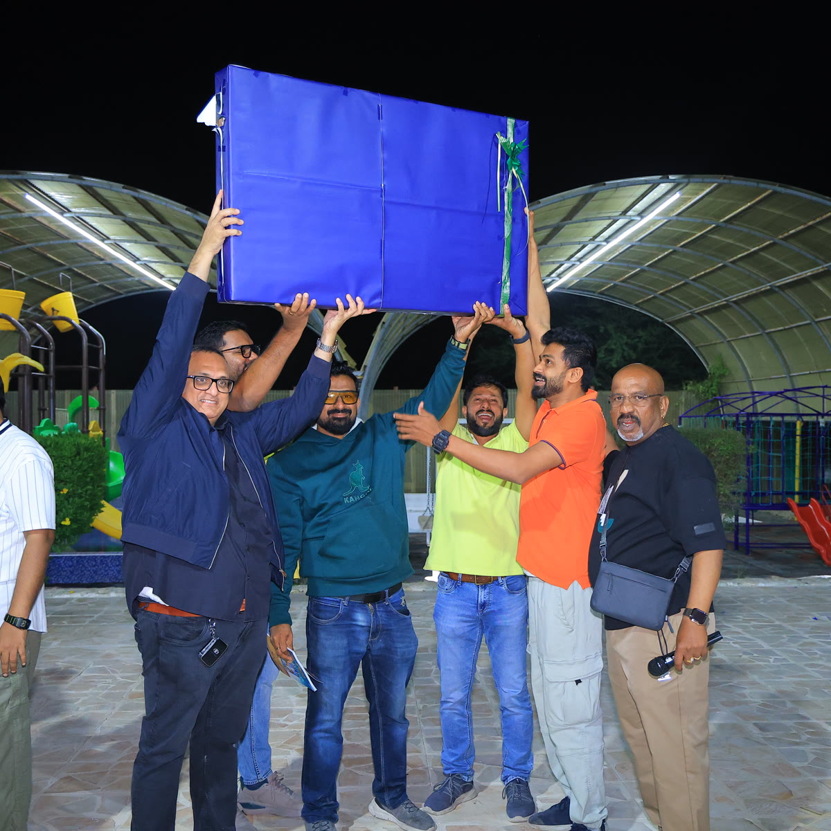 Members working together to hold up a banner during an outdoor team activity