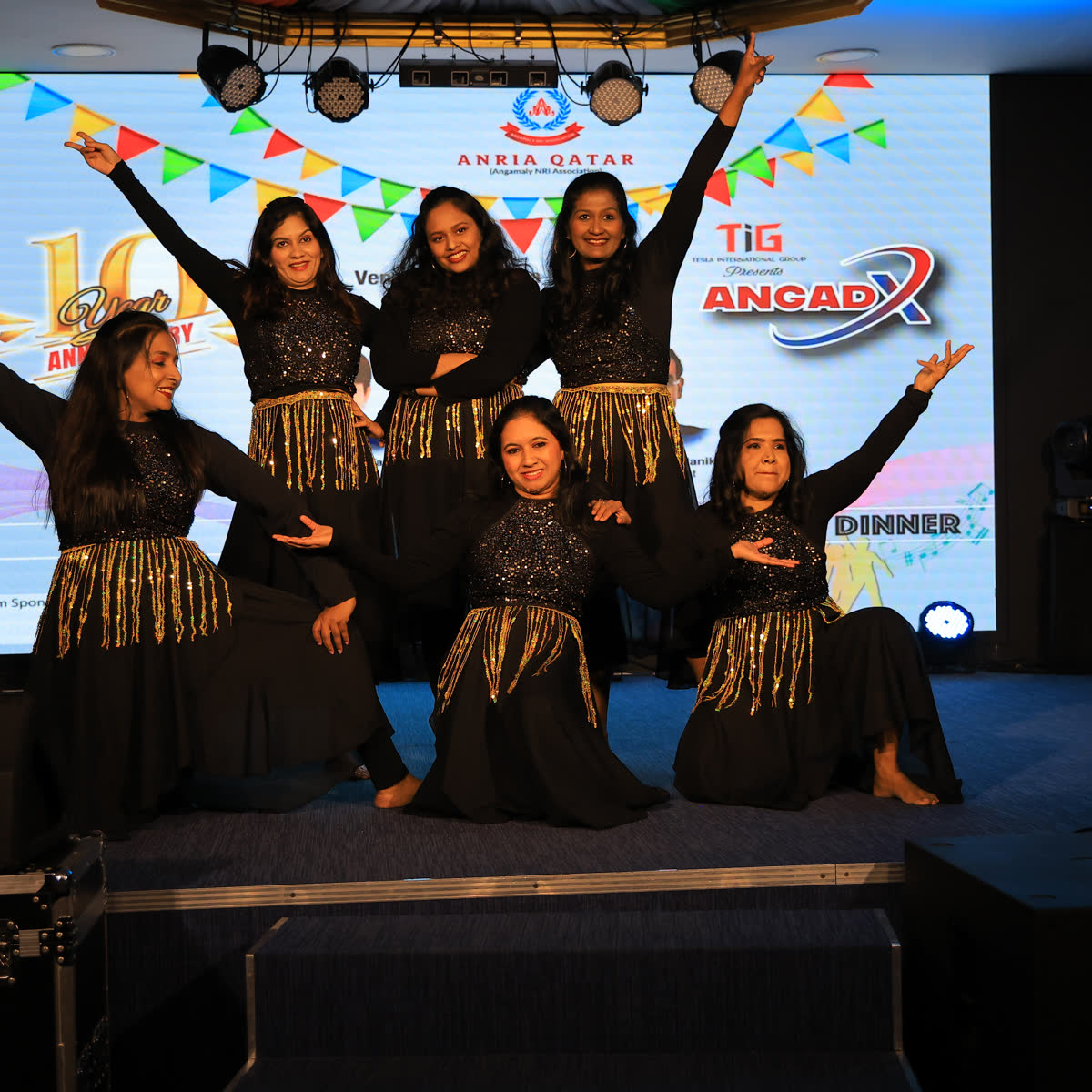 Women performing a dance item on a festively decorated stage