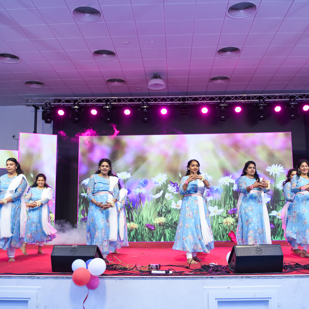 Women performing a group dance on a decorated stage